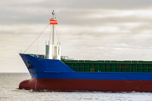 Blue cargo ship's bow leaving the port of Riga