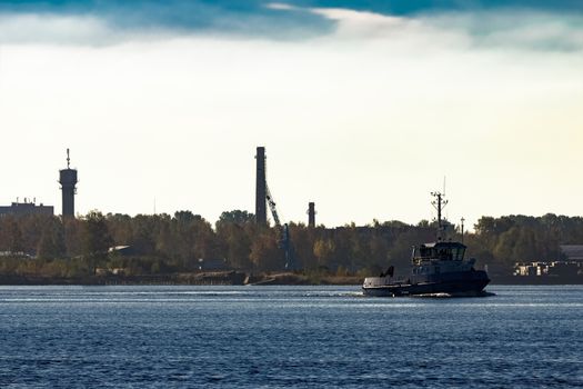 Blue small tug ship leaving Riga and entering the Baltic sea