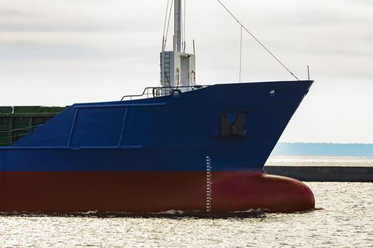 Blue cargo ship's bow leaving the port of Riga