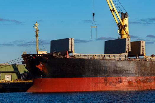 Black cargo ship loading in the port of Riga, Europe