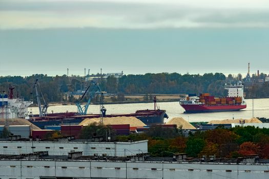 Red container ship entering port of Riga, Latvia