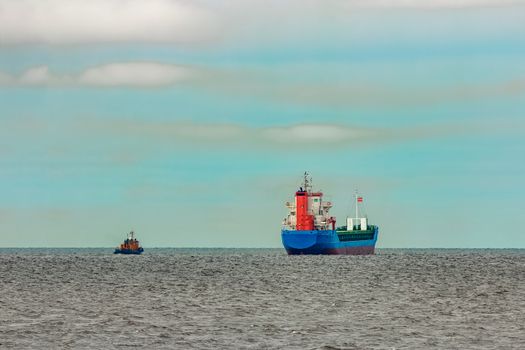 Blue cargo ship entering the Baltic sea. Riga, Europe