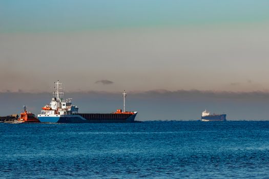 Blue cargo ship leaving Riga and entering Baltic sea