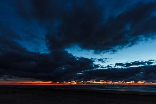 Dark blue cloudy sky over the Baltic sea at night