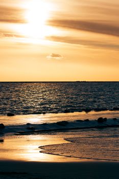 Vertical view of golden sunset at Baltic sea shore