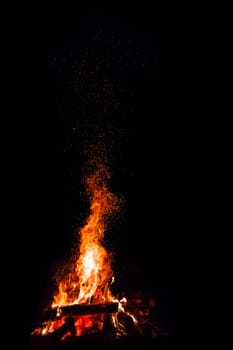 Campfire with flying sparks isolated on black background