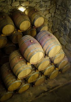 rows of wood wine barrels in a vintage winery cave
