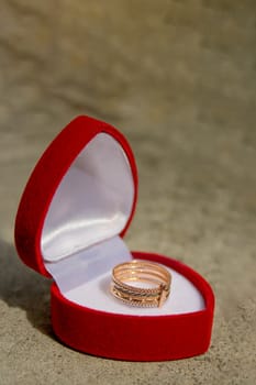 Golden week ring in a red velvet gift box. White gold jewelry