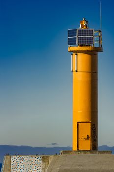 Yellow lighthouse on breakwater dam in Riga, Europe