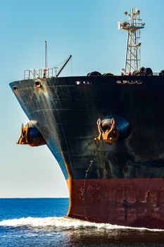 Black cargo ship's bow in still water. Riga, Europe