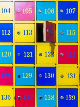 Colorful wooden lockers with numbers, one door open