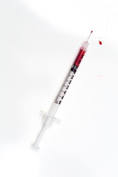 Blood-filled syringe on white background