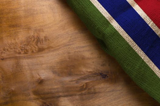 National flag of the country Gambia on a wooden background.