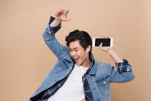 Portrait of a young asian handsome man with headphones smiling and listening to music