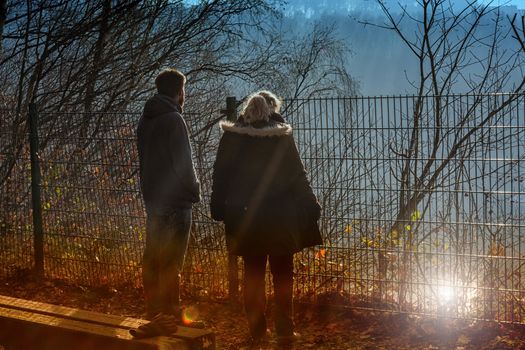 Two people on foggy morning standing at a precipice