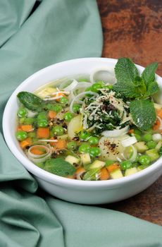 Light, refreshing soup of carrots, zucchini, potatoes, leeks, peas, pesto, parmesan and mint leaves.