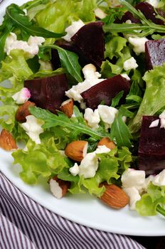 Salad vinaigrette with beets, lettuce, arugula, feta, and almonds,
