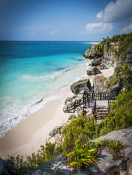 View of the crystal clear, blue waters of the Caribbean sea from a cliff in Tulum, Mexico