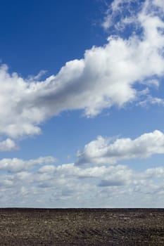 View of a plowed field under a blue sky