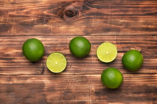 Fresh limes on wooden  table, Top view, background.