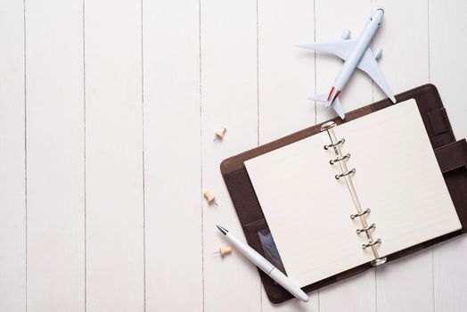 Business trip concept. Airplane and blank open notebook for your text.