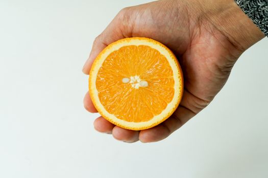 Slice organic orange holding on the hand