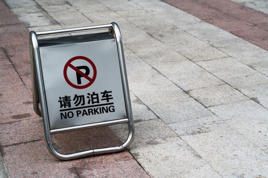 Sign on the parking lot to block the parking car in english and chinese word