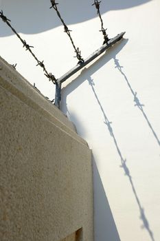 Shadow of Barbed Wire on Cement Wall.