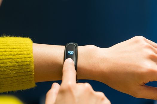 Women touching fitness smart band on her hand
