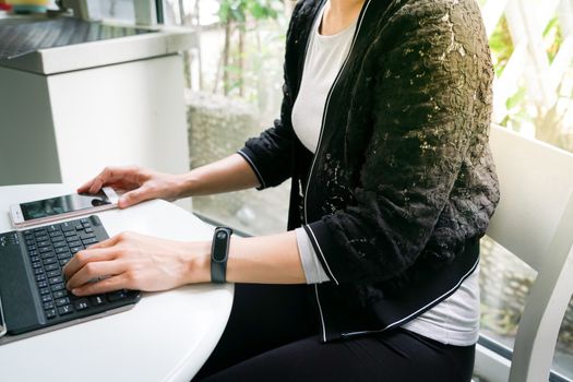 Young student women wearing smart band using tablet computer and touching smart phone