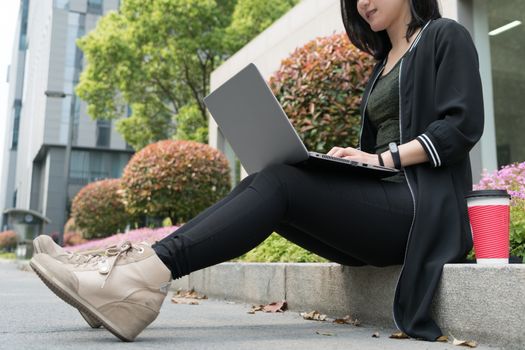 A pretty student woman is using laptop computer