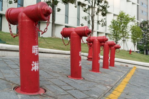 A group of red fire water hydrant beside the building