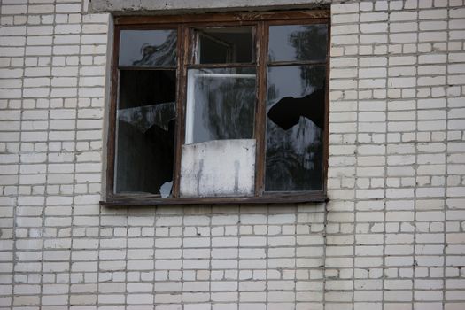 Broken windows in an old abandoned brick building