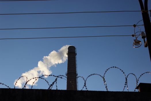 pipe smoke and a barbed wire. security plant