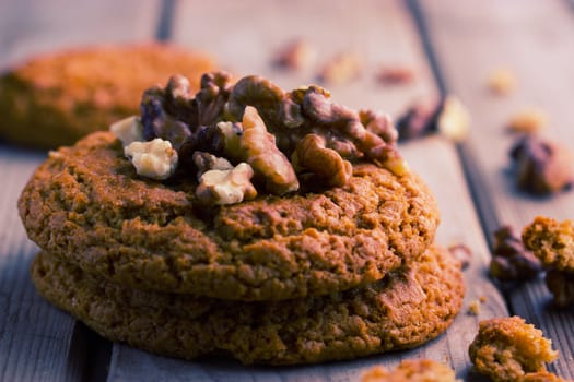 Delicious chocolate cookies with nuts on old wooden table