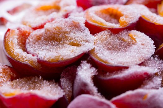 frozen half of a plum on a wooden background. Winter vitamins