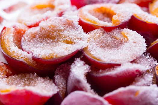 frozen half of a plum on a wooden background. Winter vitamins