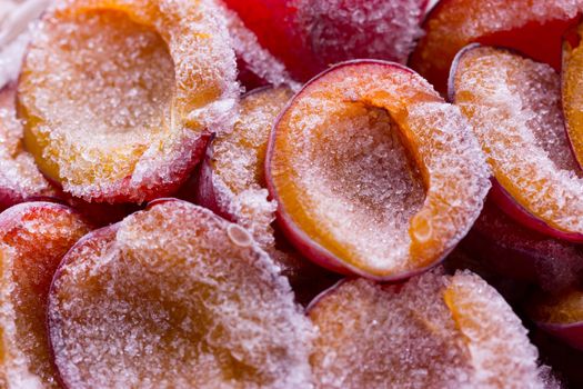 frozen half of a plum on a wooden background. Winter vitamins