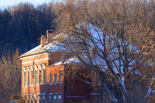 Cottage from red brick in winter landscape