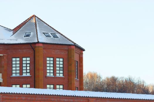 Cottage from red brick in winter landscape