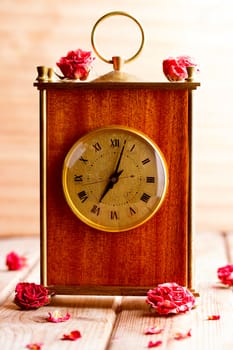 vintage style picture of an arrangement with a bouquet of roses, an clock