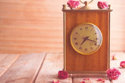 vintage style picture of an arrangement with a bouquet of roses, an clock