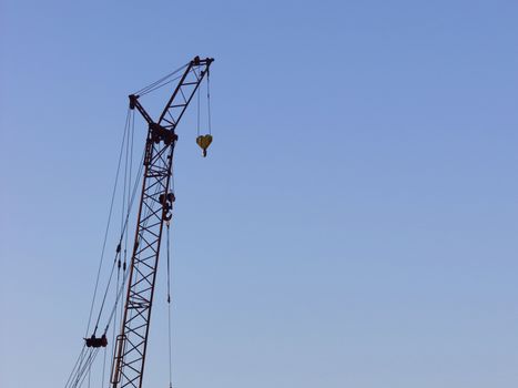 yellow construction crane on blue sky background