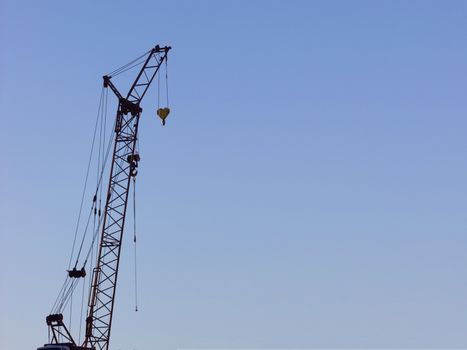 yellow construction crane on blue sky background