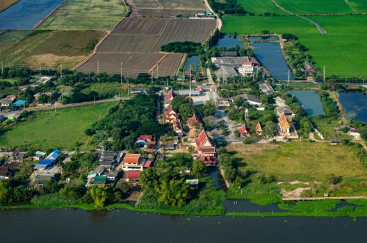 Buddhist temple, farm land, rice fields farmland in Thailand aerial photo