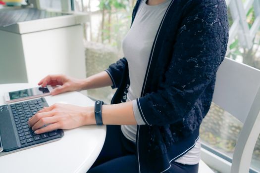 Young student women wearing smart band touching tablet computer and smart phone