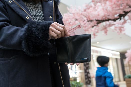 Hand holding last banknote in wallet. The woman show her last banknote from her purse on hand. poor girl.