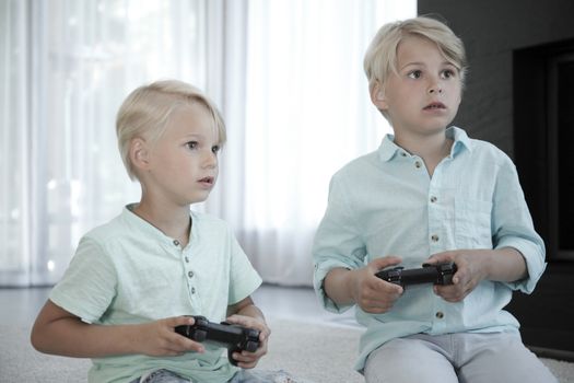 Two brothers playing video games at home