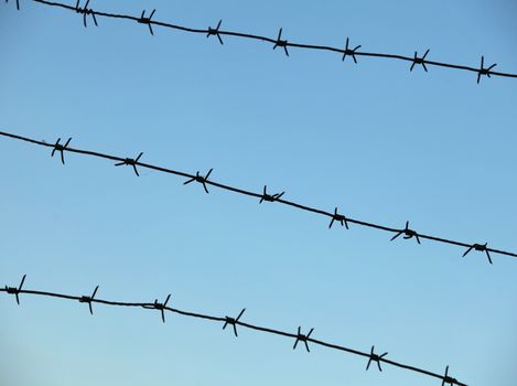 sky is enclosed by sharp barbed wire fence