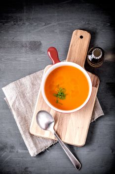 Pumpkin creme soup with a spoon served on a table